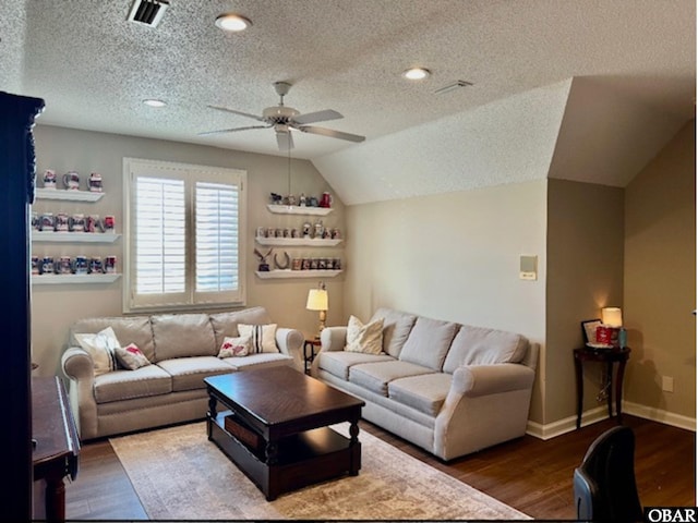 living room with baseboards, visible vents, a ceiling fan, dark wood-type flooring, and vaulted ceiling