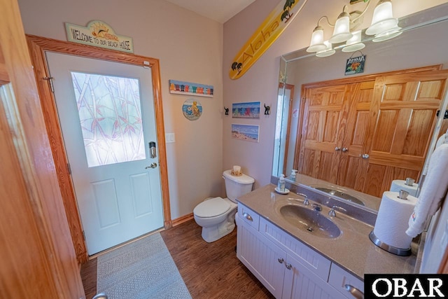 39972 NC-12 Hwy Lot 15, Avon, NC 27915 - bathroom with a notable chandelier, toilet, wood finished floors, baseboards, and vanity