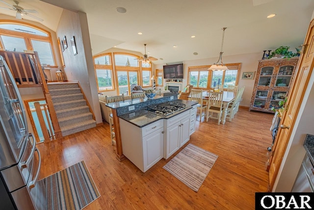 39972 NC-12 Hwy Lot 15, Avon, NC 27915 - kitchen with a fireplace, light wood-style floors, stainless steel gas stovetop, white cabinetry, and a ceiling fan