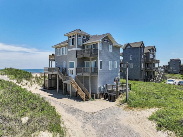 back of property with stairs and a water view