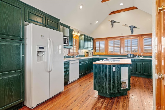 kitchen with white appliances, a sink, a kitchen island, light wood-style floors, and light countertops