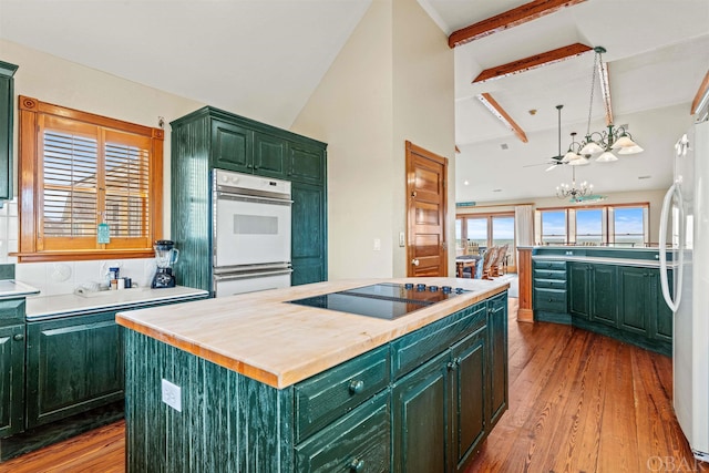 kitchen with white double oven, light wood-style flooring, black electric cooktop, a kitchen island, and green cabinetry