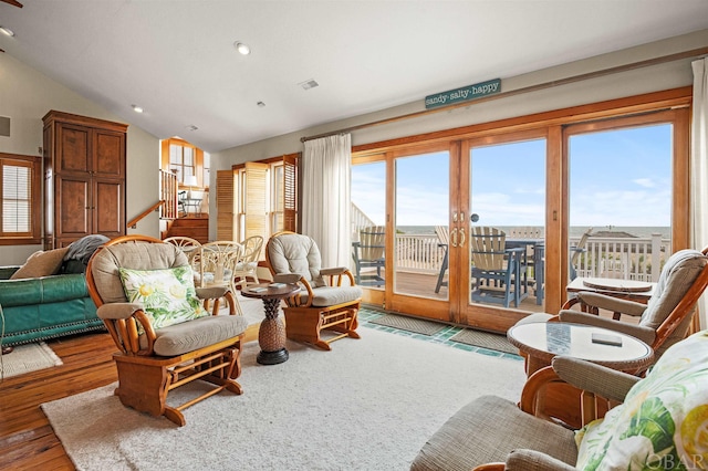 living area featuring vaulted ceiling, wood finished floors, and a wealth of natural light