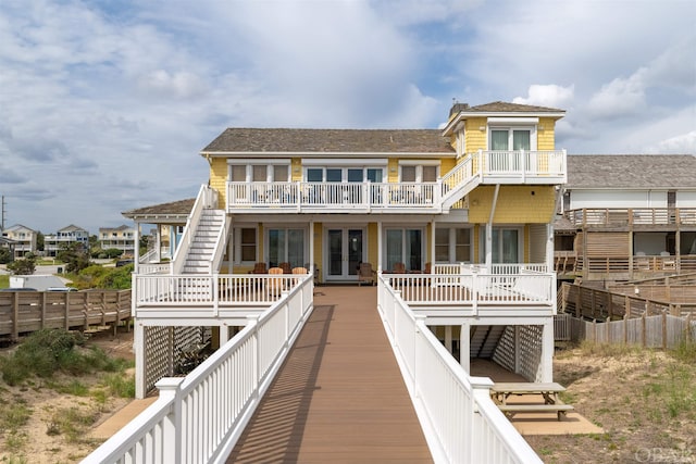 back of property featuring a balcony and fence