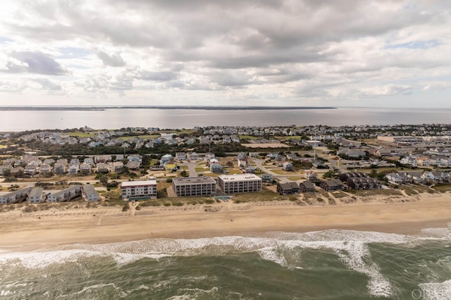 drone / aerial view featuring a view of the beach, a water view, and a residential view