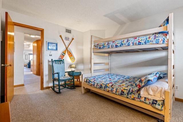 carpeted bedroom with baseboards, visible vents, and a textured ceiling