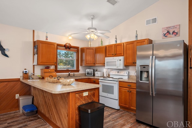 kitchen with visible vents, white appliances, light countertops, and a peninsula