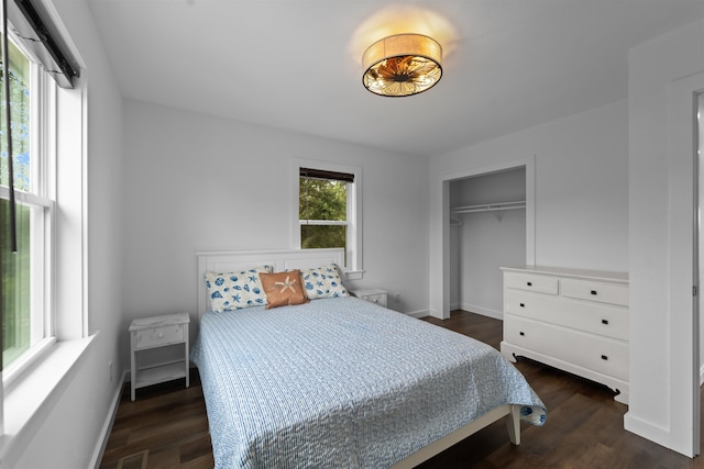 bedroom featuring dark wood-type flooring, a closet, visible vents, and baseboards