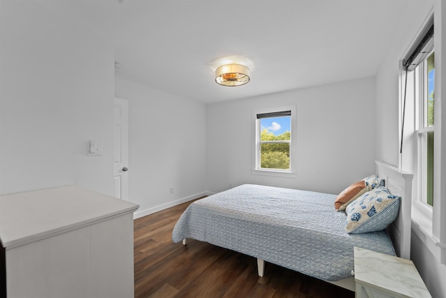 bedroom with dark wood-style floors and baseboards