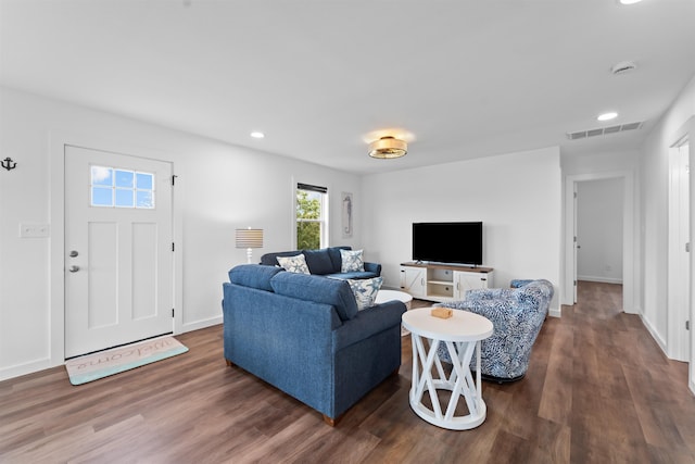 living room featuring baseboards, visible vents, wood finished floors, and recessed lighting