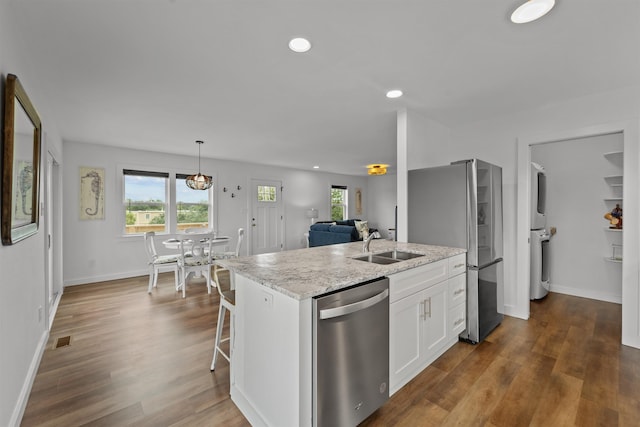 kitchen featuring stainless steel appliances, dark wood-style flooring, a sink, and white cabinets