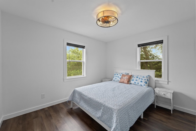 bedroom featuring dark wood-style flooring and baseboards