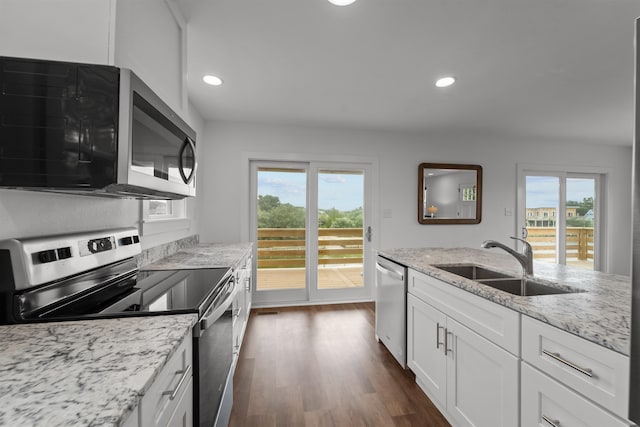 kitchen with stainless steel appliances, dark wood-style flooring, a sink, white cabinets, and plenty of natural light