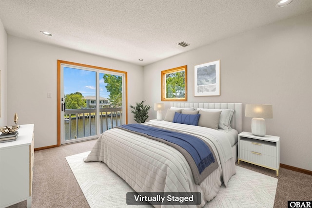4005 Ivy Ln Lot # 16, Kitty Hawk, NC 27949 - bedroom with light colored carpet, access to exterior, a water view, a textured ceiling, and baseboards