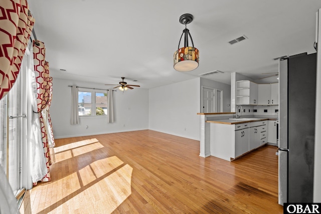 1612 Harbour View Dr Lot 114, Kill Devil Hills, NC 27948 - kitchen featuring freestanding refrigerator, ceiling fan, light wood-style floors, white cabinets, and hanging light fixtures