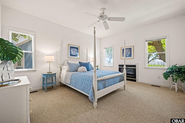 506 Magnolia Way Lot 29, Corolla, NC 27927 - bedroom with light carpet, a ceiling fan, and a tile fireplace