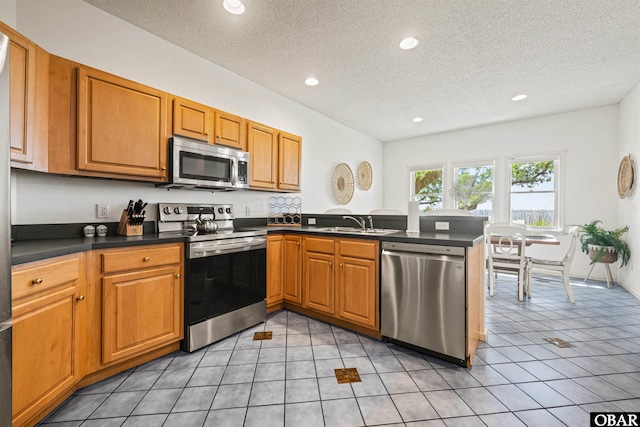 506 Magnolia Way Lot 29, Corolla, NC 27927 - kitchen featuring appliances with stainless steel finishes, a peninsula, dark countertops, a textured ceiling, and recessed lighting