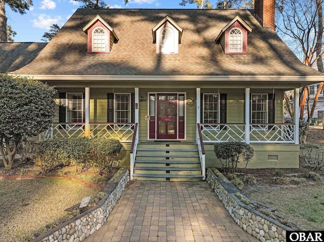 view of front facade with crawl space, covered porch, a chimney, and roof with shingles