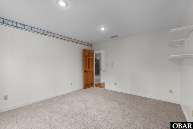 carpeted spare room featuring attic access, visible vents, baseboards, and recessed lighting