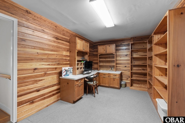 office featuring light carpet and wooden walls