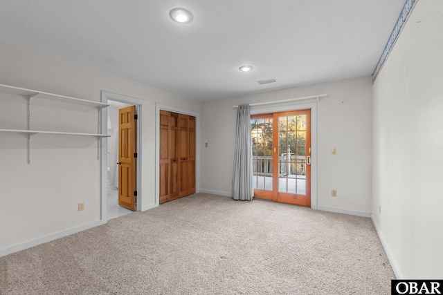 unfurnished bedroom with baseboards, carpet, visible vents, and access to exterior