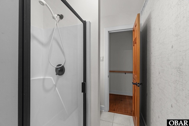 bathroom with a shower stall and tile patterned floors