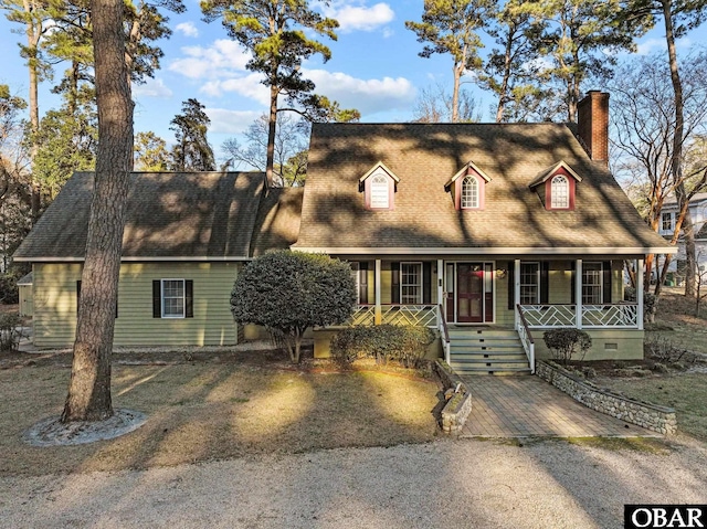 view of front of home featuring a shingled roof, covered porch, and a chimney