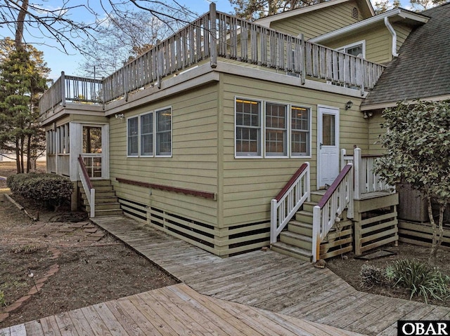 rear view of property with a balcony and a shingled roof