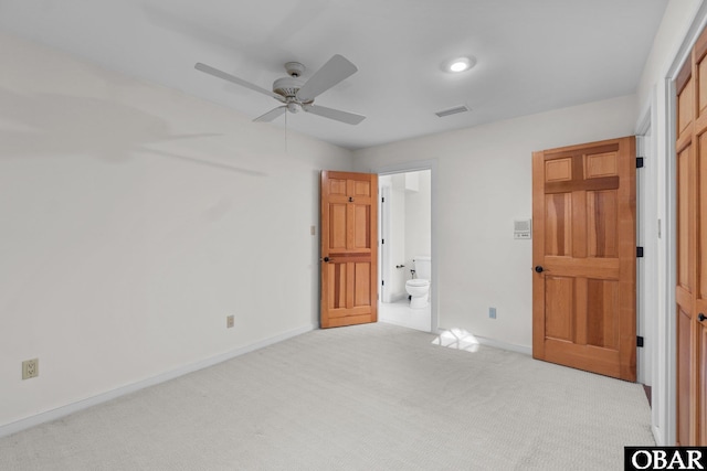 unfurnished bedroom with light carpet, connected bathroom, visible vents, and baseboards