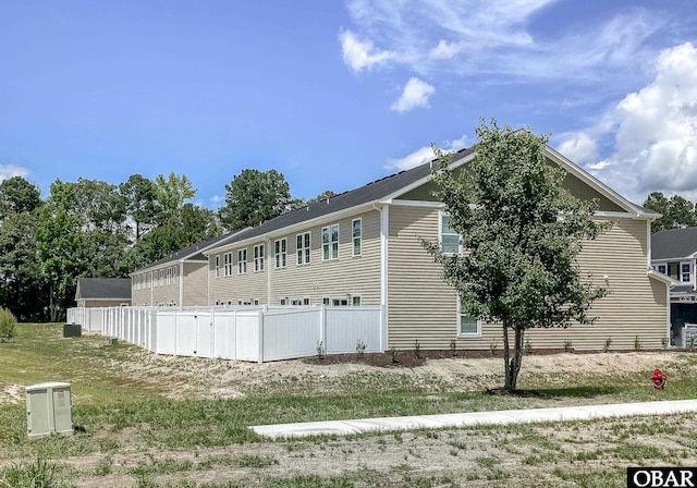 view of side of home featuring fence