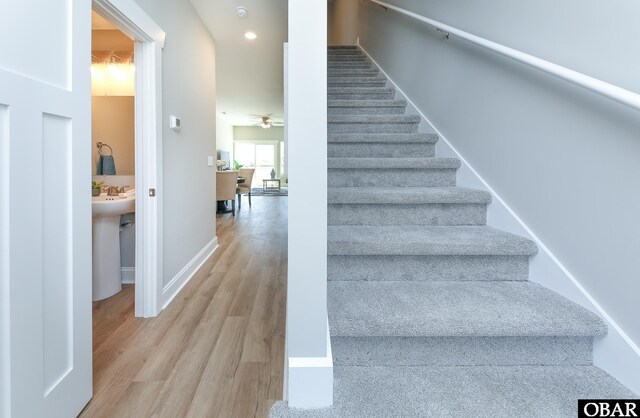 staircase featuring a ceiling fan, recessed lighting, baseboards, and wood finished floors