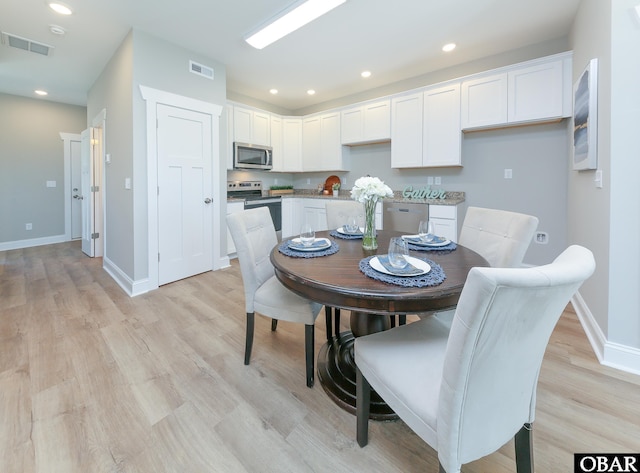 dining room with light wood-style floors, visible vents, and recessed lighting