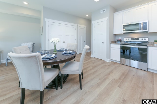 dining room with baseboards, light wood-type flooring, visible vents, and recessed lighting