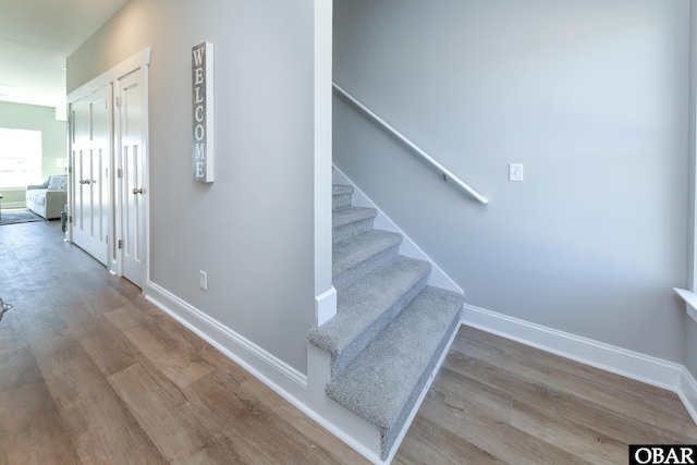 stairs with wood finished floors and baseboards