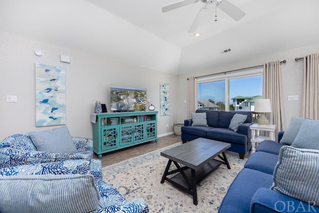 living room featuring visible vents, a ceiling fan, vaulted ceiling, wood finished floors, and baseboards