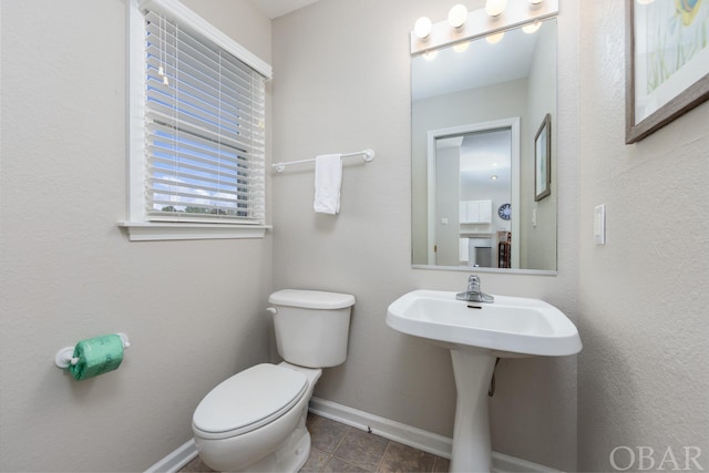 half bathroom featuring toilet and baseboards