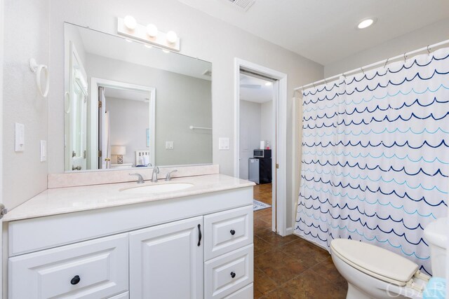 bathroom featuring toilet, curtained shower, tile patterned floors, and vanity