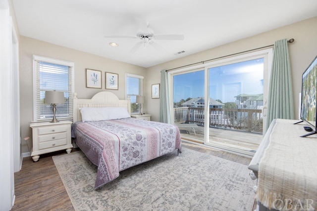 bedroom featuring ceiling fan, wood finished floors, visible vents, baseboards, and access to exterior