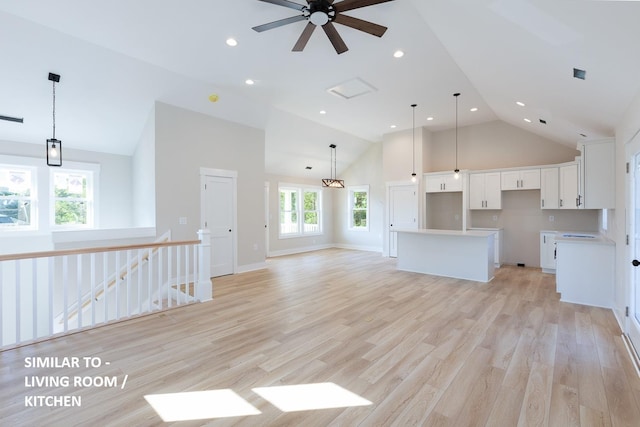 unfurnished living room with high vaulted ceiling, recessed lighting, a ceiling fan, baseboards, and light wood finished floors