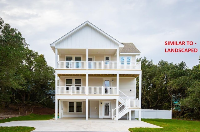 coastal home featuring a balcony, stairway, covered porch, board and batten siding, and a front yard