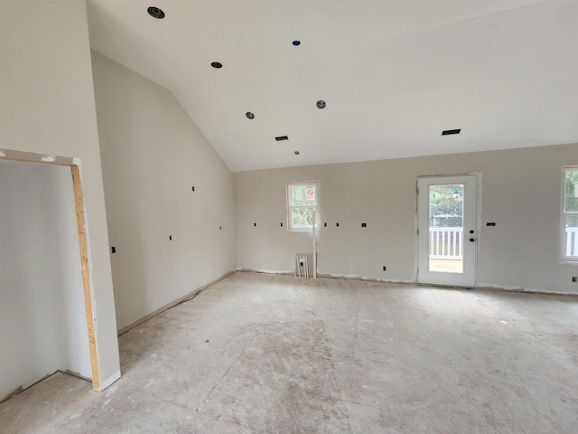 empty room featuring plenty of natural light and vaulted ceiling