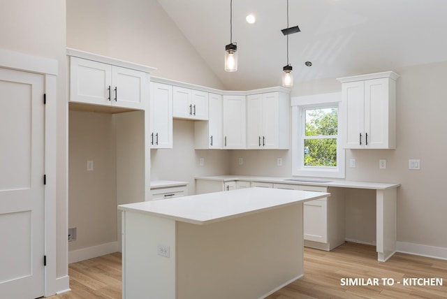 kitchen with white cabinetry, light countertops, hanging light fixtures, light wood-type flooring, and a center island