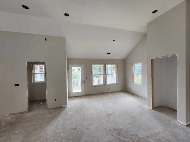 unfurnished living room with high vaulted ceiling and a wealth of natural light