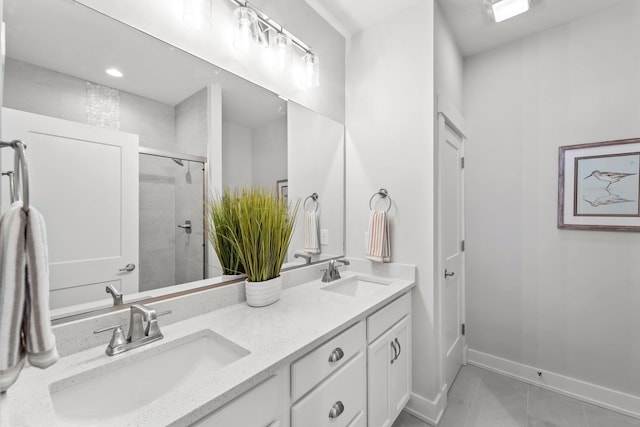 full bathroom with double vanity, tile patterned flooring, baseboards, and a sink