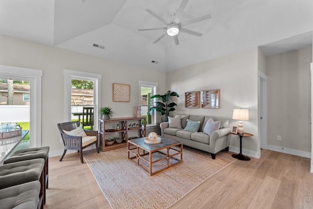 living room with ceiling fan, lofted ceiling, visible vents, baseboards, and light wood-type flooring