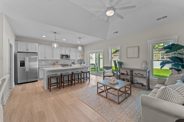 living room with light wood finished floors, visible vents, lofted ceiling, ceiling fan, and recessed lighting