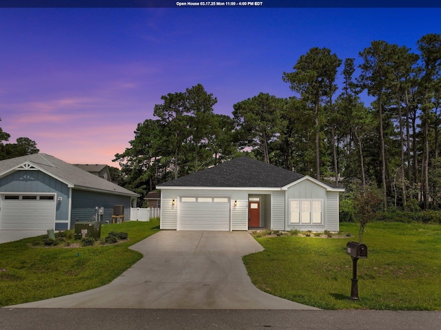 ranch-style house featuring board and batten siding, a front yard, fence, and a garage