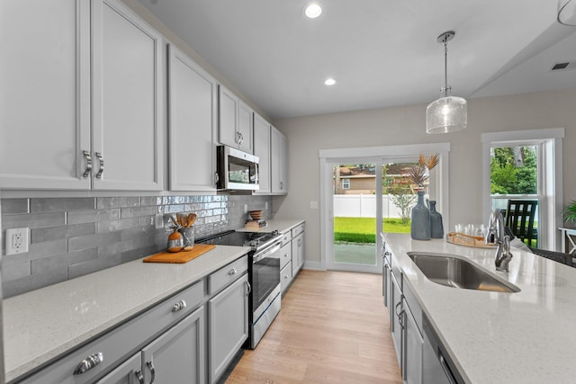 kitchen with a wealth of natural light, visible vents, a sink, backsplash, and appliances with stainless steel finishes