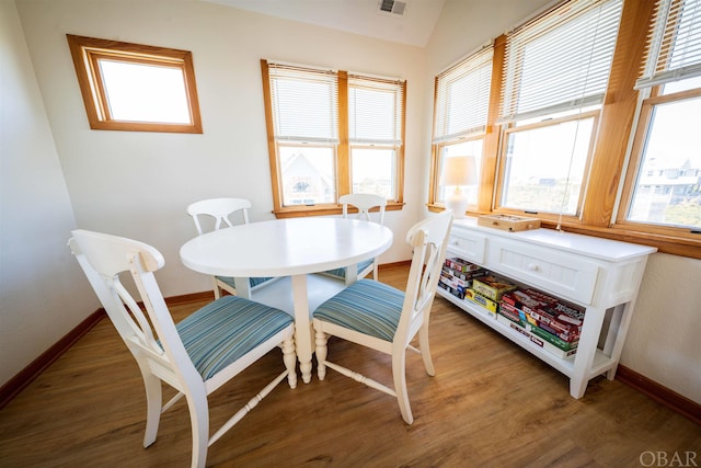 dining room with dark wood-style flooring, visible vents, and baseboards