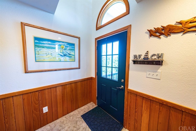 entryway with a wainscoted wall and wooden walls